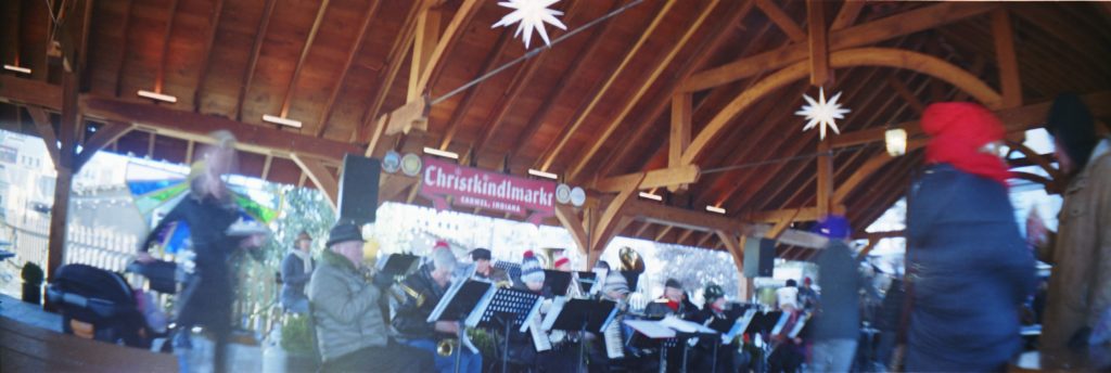 Photo of a brass band under am outdoor shelter.